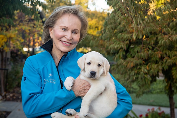 Christine Benninger holds a yellow Lab guide dog puppy